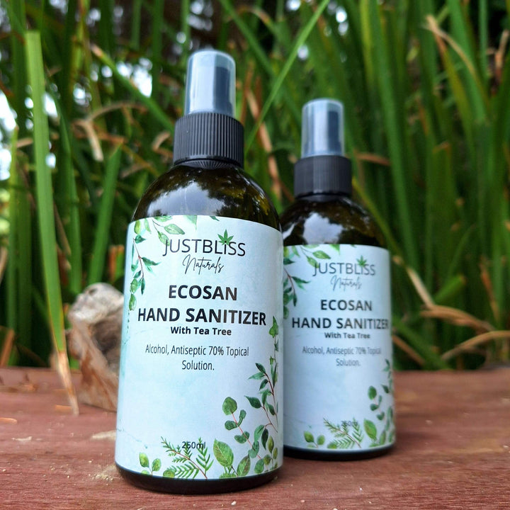 EcoSan 70% Alcohol Hand Sanitizer with Tea Tree Essential Oil bottles on wooden surface