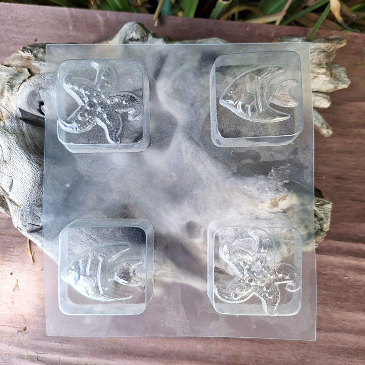 DIY glycerin soap making kit molds: starfish and fish shapes on textured wood background.
