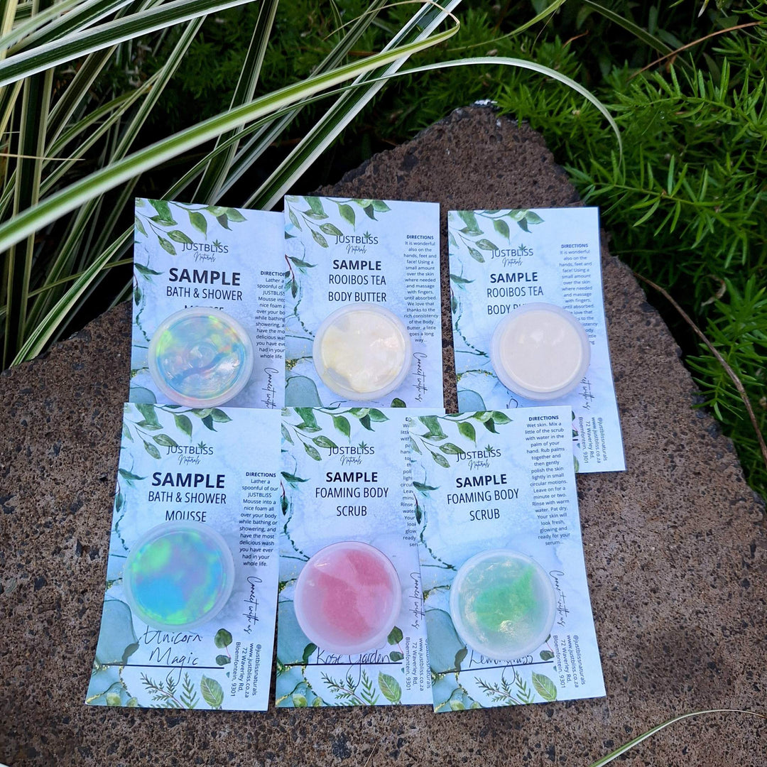 Luxury plant-based skincare and body care starter kit samples by JUSTBLiSS, displayed outdoors.