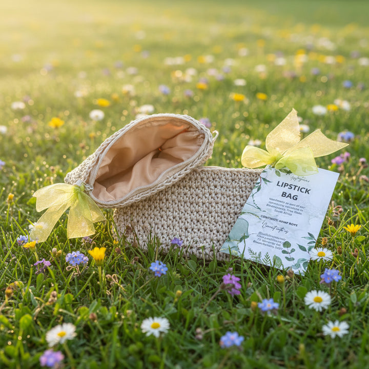 Beige lipstick bag with a green bow and label on a dark surface