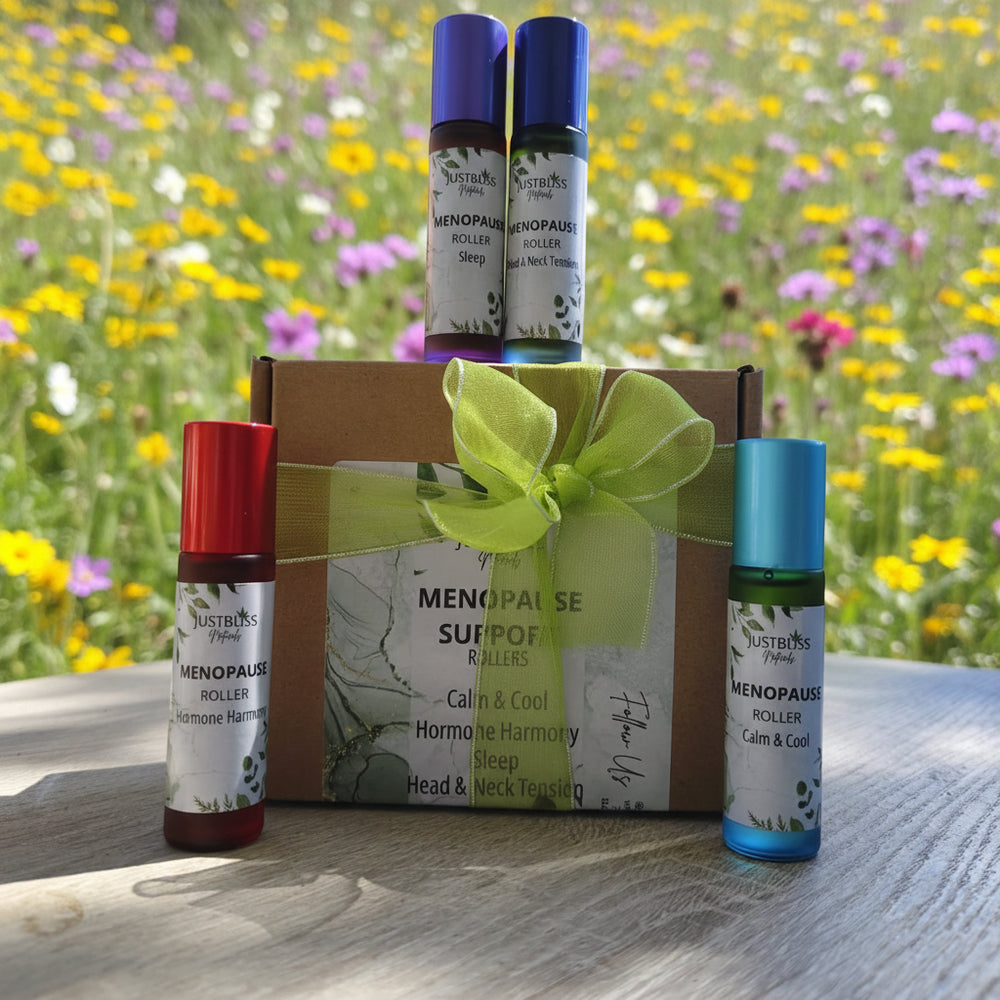 Menopause support roller bottles with a gift box on a wooden surface outdoors.