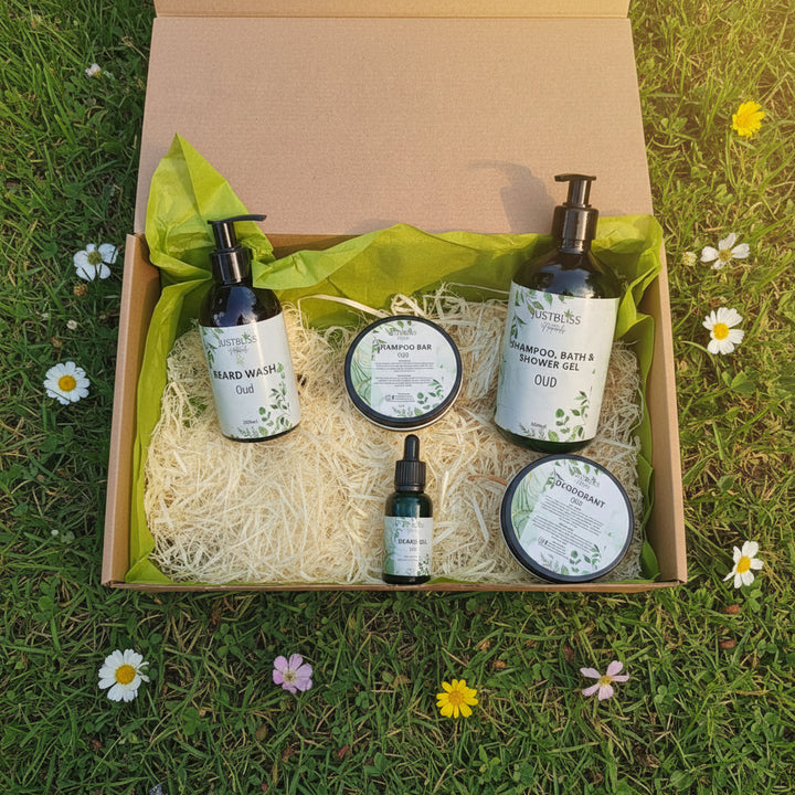 Set of JUSTBLiSS Naturals skincare products including beard wash, shampoo bar, shampoo, bath &amp; shower gel, beard oil, and deodorant in a box.