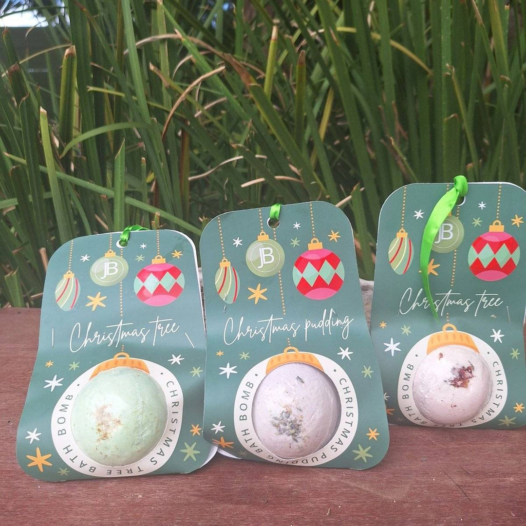 Christmas themed bath bombs with festive packaging displayed outdoors.