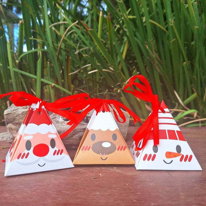 Christmas themed bath bomb packaging with festive characters and red ribbons.