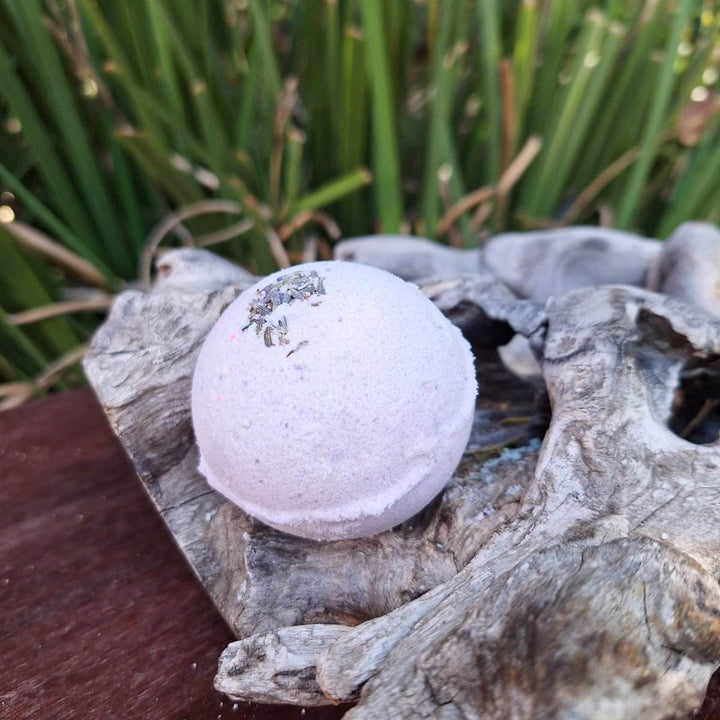 Christmas themed bath bomb with lavender and shea butter on a rustic wooden surface.