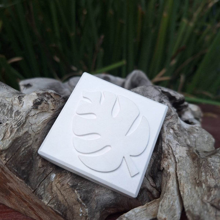 Clay diffuser stone with minimalist design, placed on a natural wood background.