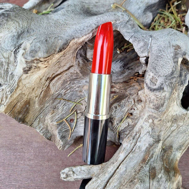 Lipstick Pen with ink resting on driftwood background.