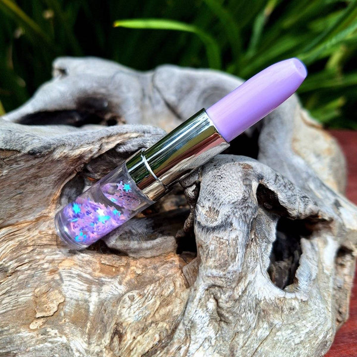 Lipstick pen with vibrant color against natural wood backdrop.