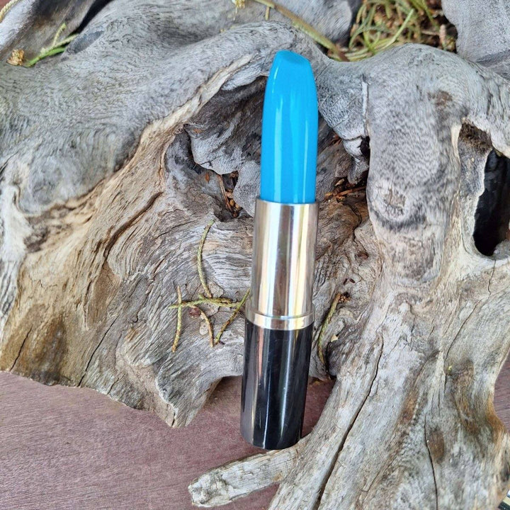 Blue lipstick pen with a silver and black case, placed on a textured wooden background.