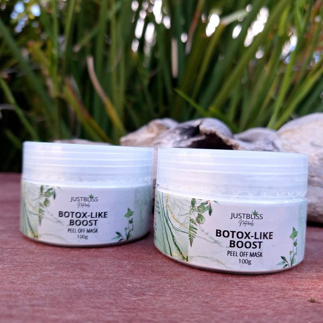 Botox-like Boost Clay Face Mask jars on a wooden surface with greenery background.