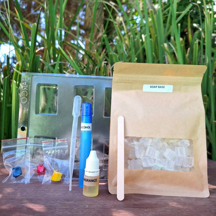 DIY glycerin soap making kit with ingredients and tools displayed outdoors.
