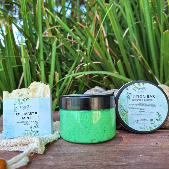Rosemary & Mint Gift Box 2 gift set featuring natural skincare products, including soap bar, body scrub, and lotion bar, displayed outdoors.