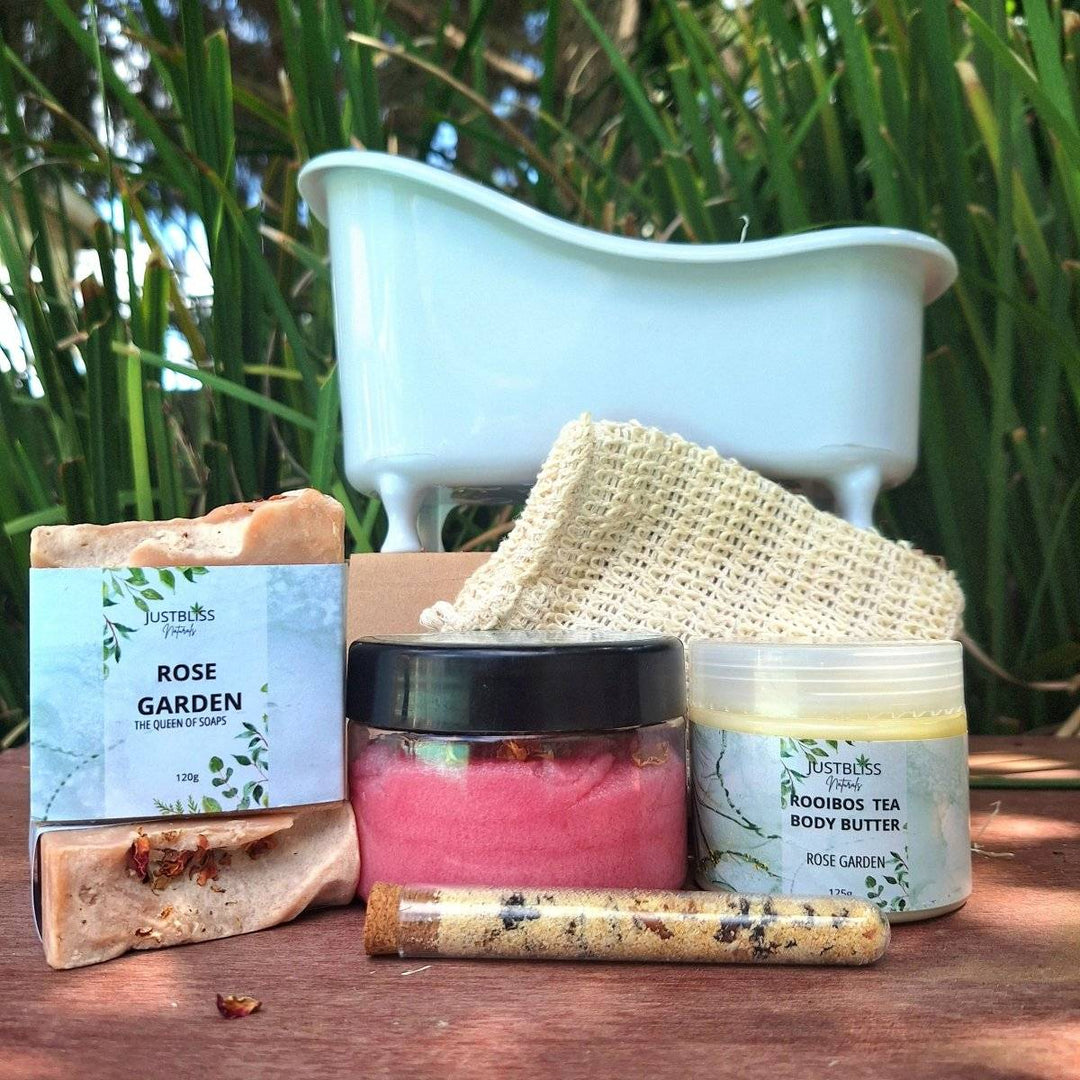 Gift box with spa bath products including body scrub, bath salt tube, artisan soap, sisal soap saver, and rooibos tea body butter in Rose Garden scent.