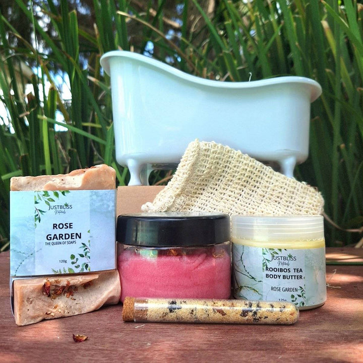 Gift box with spa bath products including body scrub, bath salt tube, artisan soap, sisal soap saver, and rooibos tea body butter in Rose Garden scent.