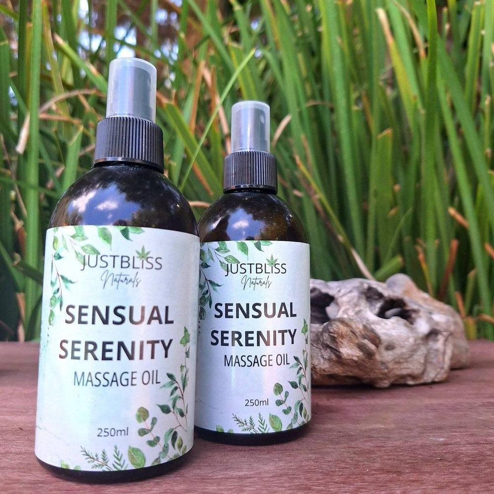 Sensual Serenity Massage Oil bottles with green foliage in the background, 250ml size.