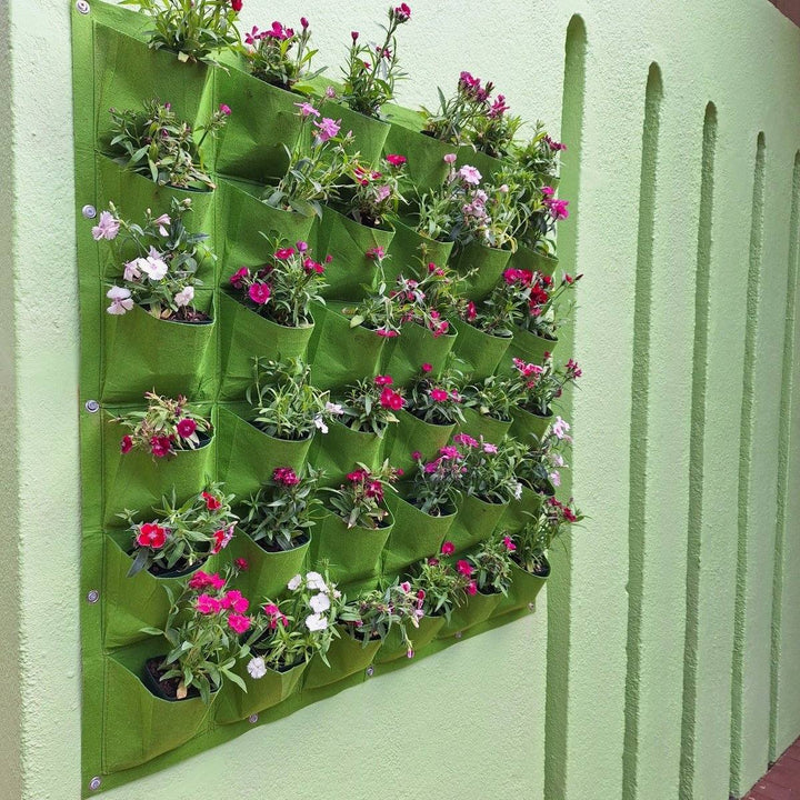 Vertical garden living wall planter with 36 green pockets, holding vibrant flowers and enhancing space.