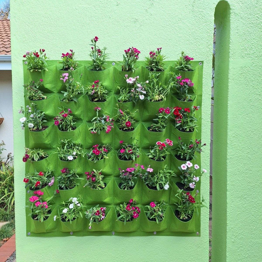 Vertical garden wall planter with 36 pockets holding vibrant flowers, enhancing air quality and aesthetics.