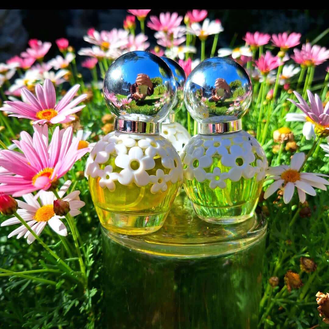 30ml floral perfume bottles with oil-based fragrance placed amidst colorful flowers.