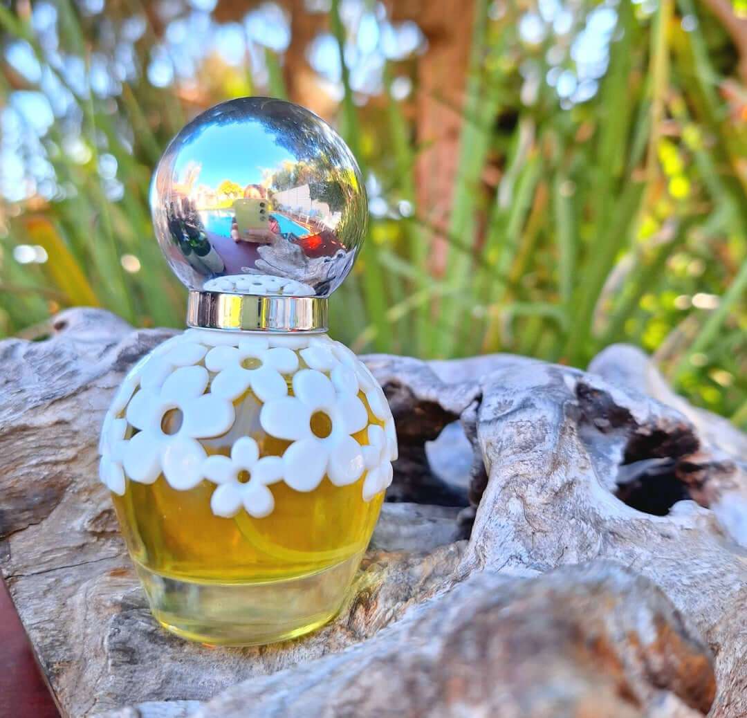 30ml floral perfume in decorative bottle with white floral design, set on natural wood background.