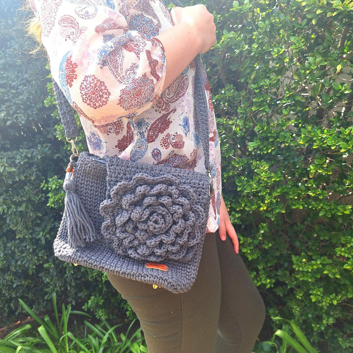 Hand-crafted handbag with floral design made from cotton wool displayed outdoors.