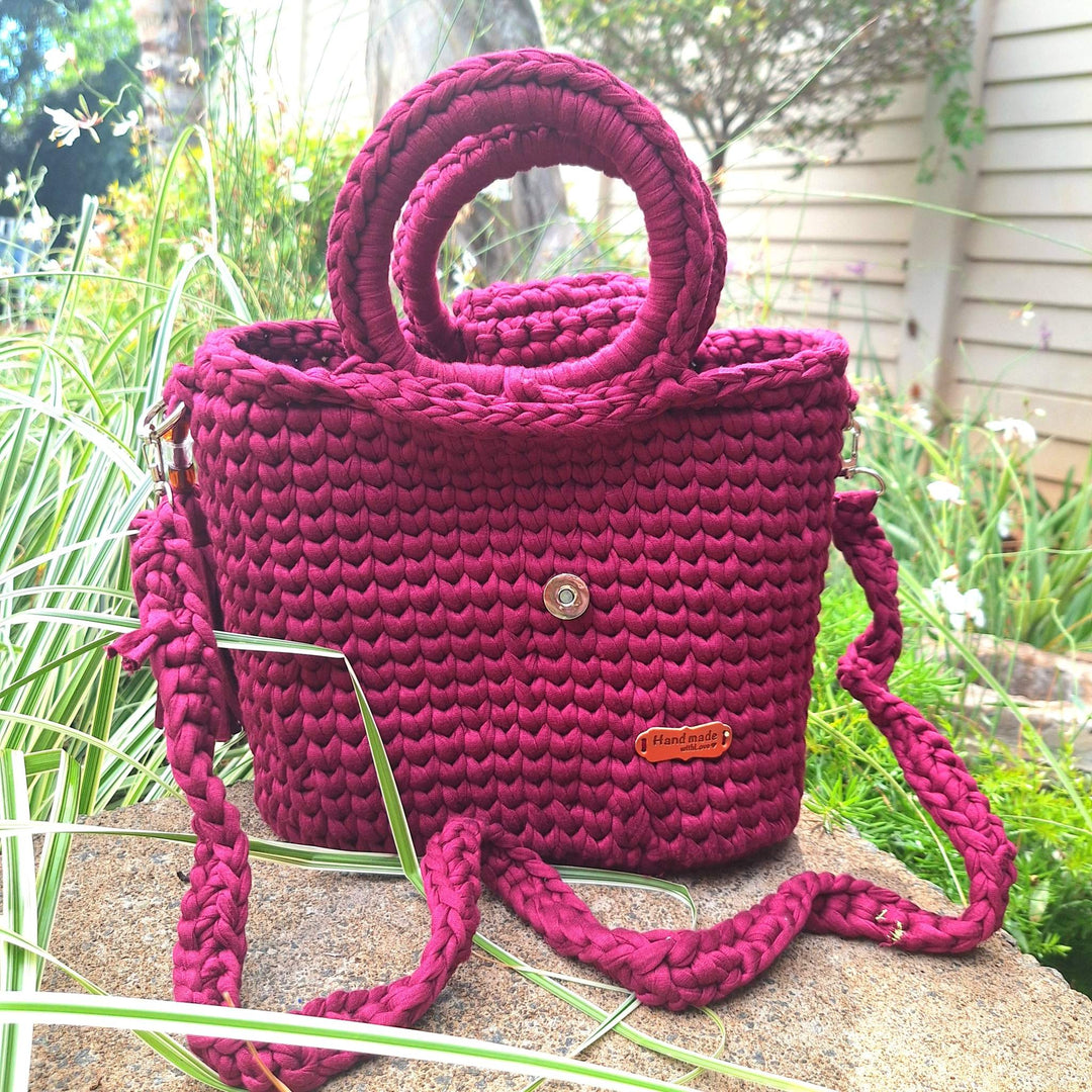 Hand-crafted handbag made of cotton wool, featuring a spacious design and detailed stitching, shown in an outdoor setting.
