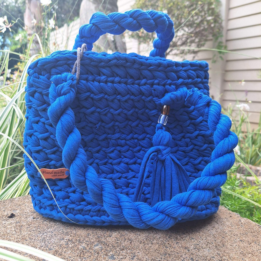 Hand-crafted handbag made from cotton wool with braided strap and tassel detail.