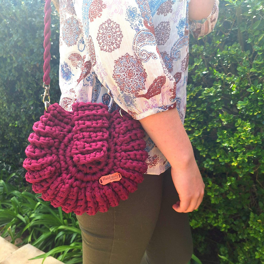 Hand-crafted handbag made of cotton wool, being held by a person outdoors.