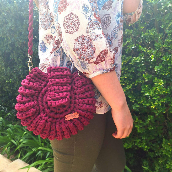 Hand-crafted handbag made of cotton wool, being held by a person outdoors.