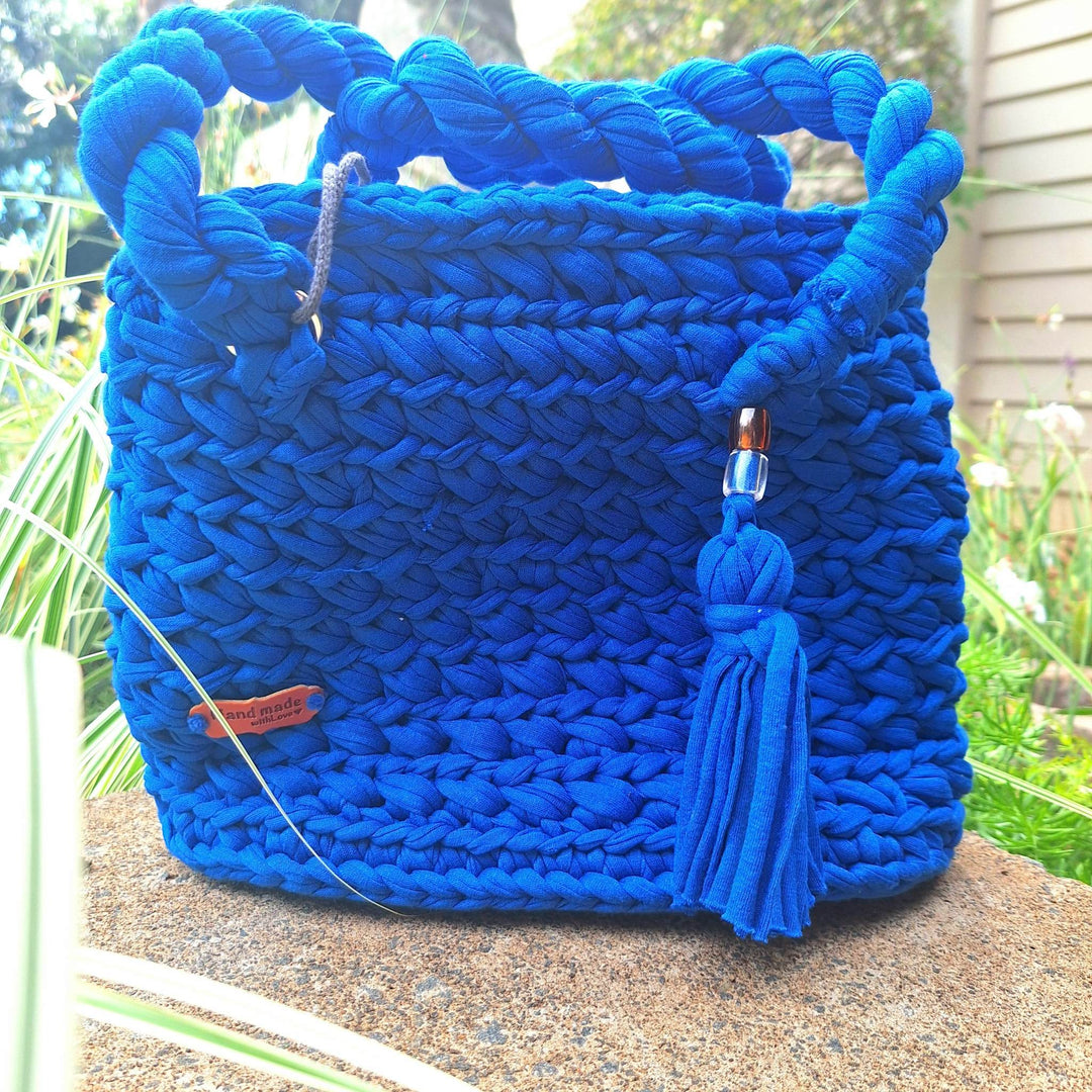 Handcrafted handbag made of cotton wool with braided handle and tassel, showcasing natural elegance.