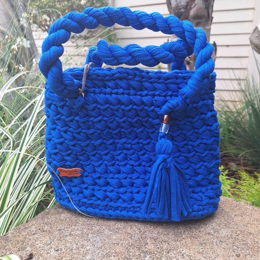Hand-crafted handbag with braided handles and tassel, made from cotton wool.