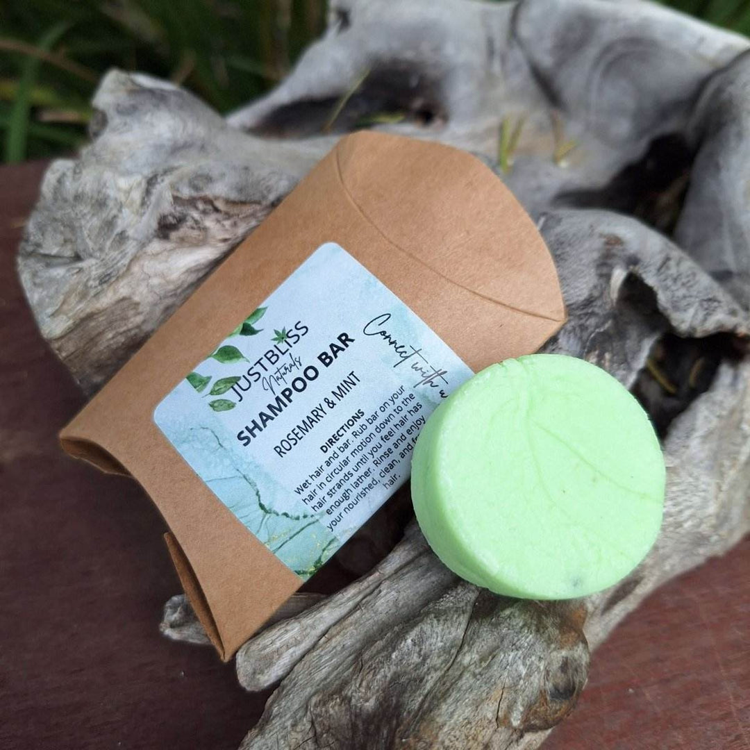 Rosemary & Mint travel size shampoo bar with eco-friendly packaging on driftwood.