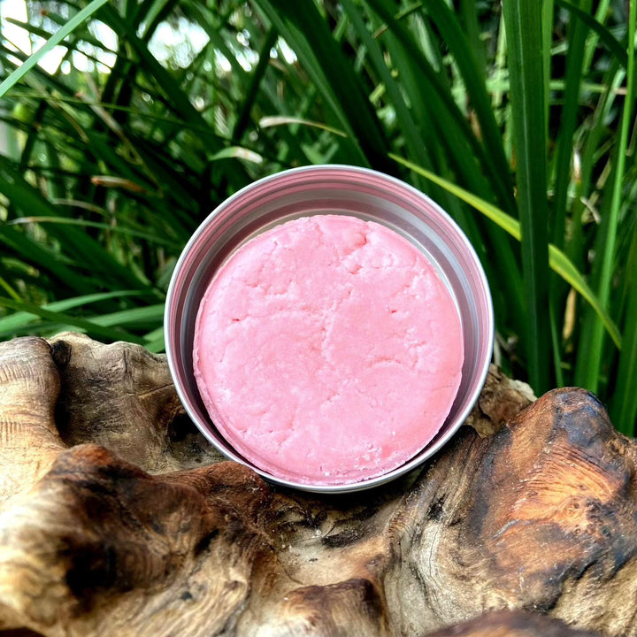Aluminium travel tin with pink dry shampoo bar for easy airport security clearance.
