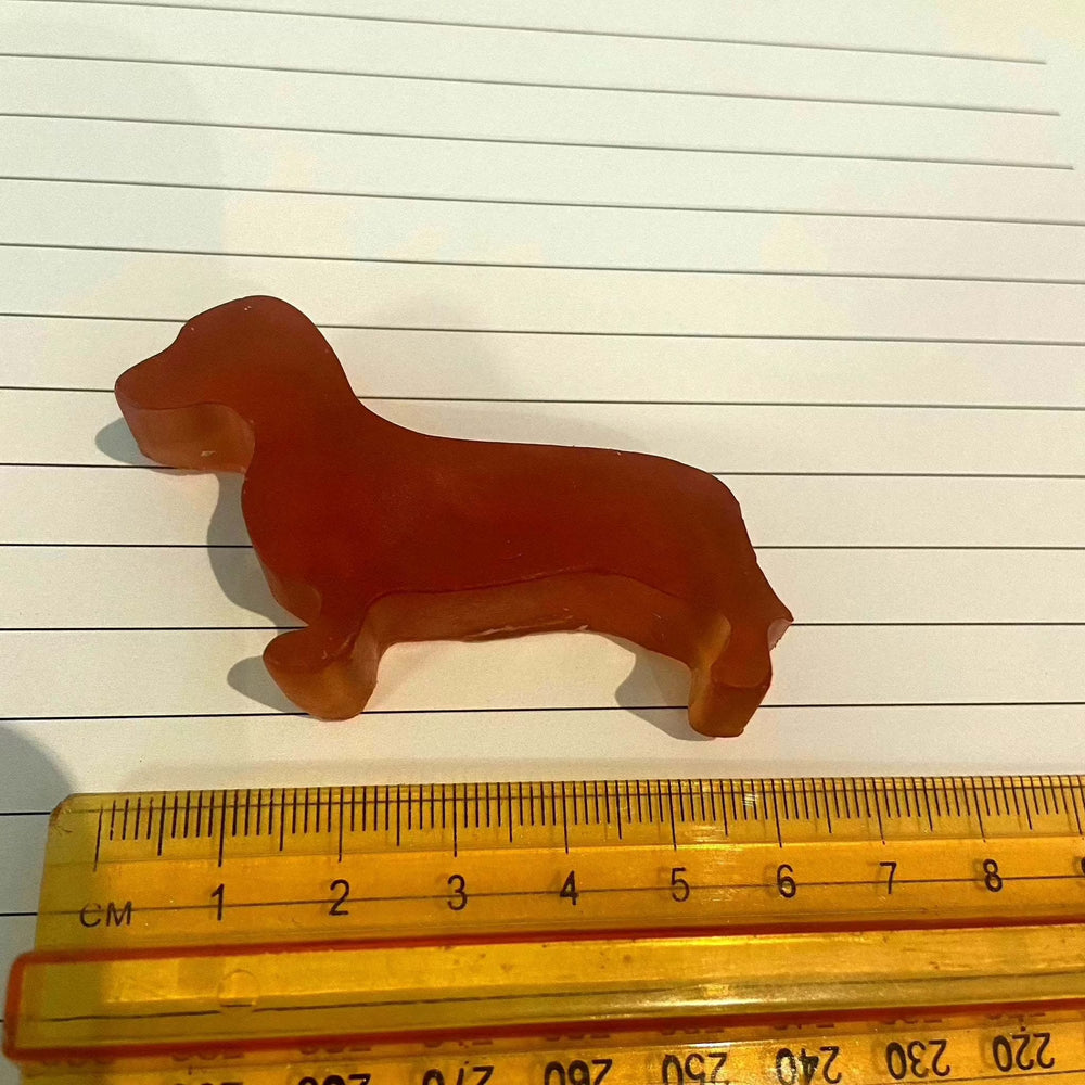 Sausage dog-shaped glycerine soap bar with ruler for scale.
