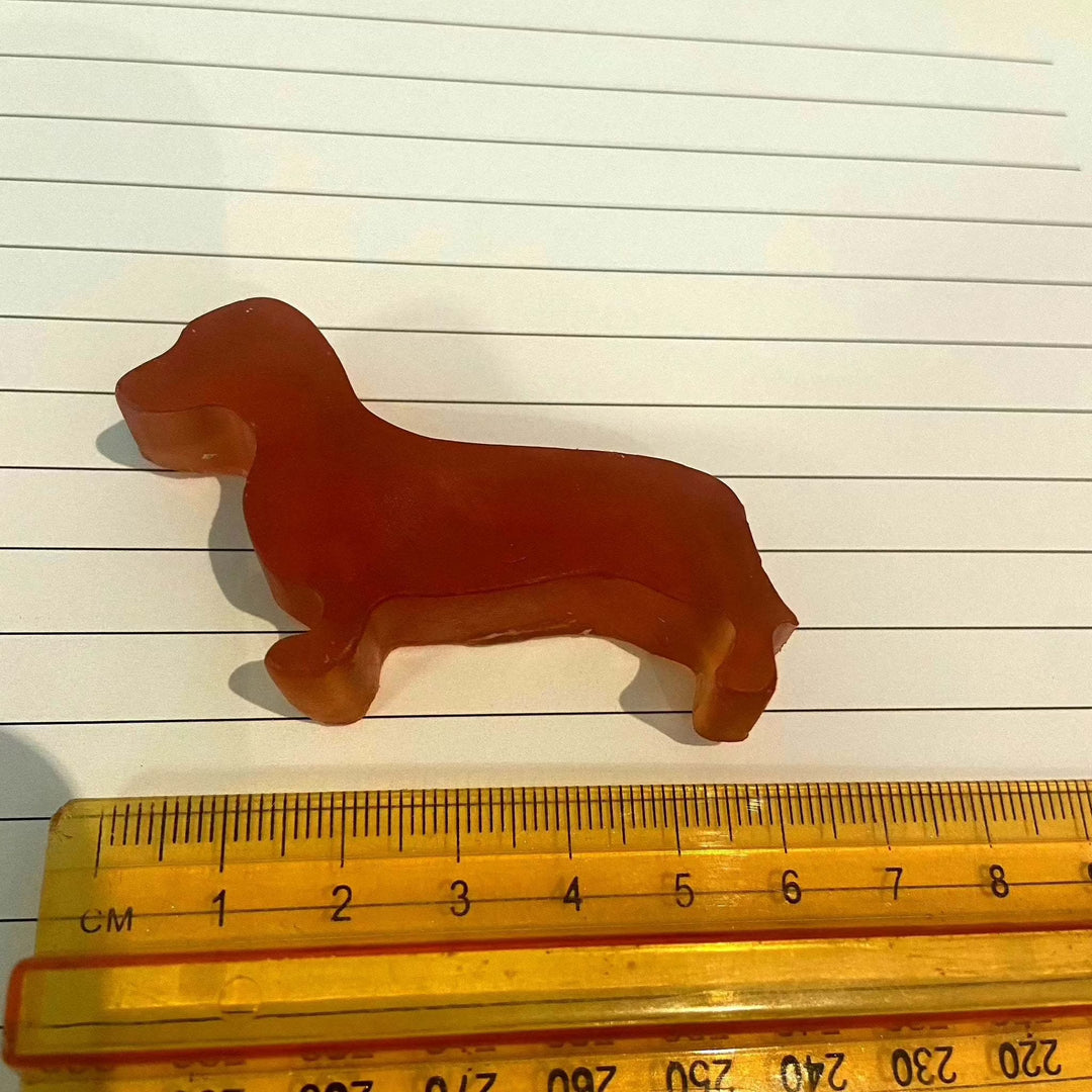 Sausage dog-shaped glycerine soap bar with ruler for scale.